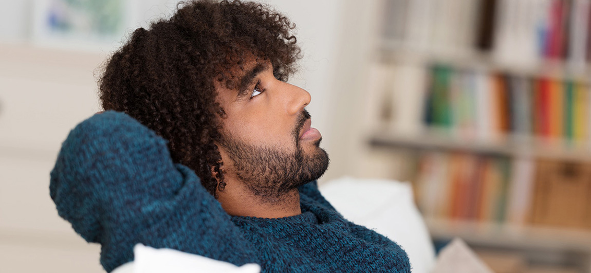 Young African American man sitting thinking